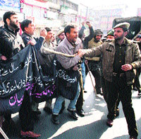 Police personnel stop people from taking out an Ashura procession at Lal Chowk on Sunday.