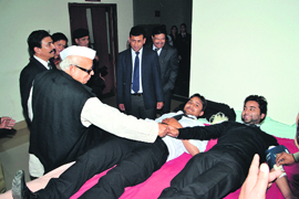Uttarakhand Governor Dr Aziz Qureshi shaking hands with student blood donors at Law College in Dehradun on Monday.