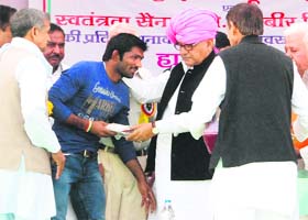 Haryana Chief Minister Bhupinder Singh Hooda honours Olympic medal winner Yogeshwar Dutt at a public meeting in Bhanswal Kalan village, Sonepat, on Monday