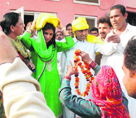 Villagers welcome Renuka Bishnoi with turbans and garlands in a Fatehabad village on Friday. 