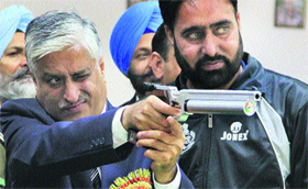 Punjab DGP Sumedh Singh Saini tries his hand at a pistol on the inaugural day of the sixth All India Police Shooting (Sports) Championship at the PAP shooting range in Jalandhar on Monday.