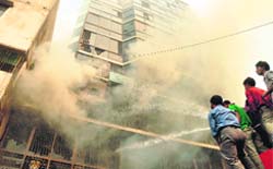 Firefighters try to douse the flames in a garment factory near Dhaka on Monday.  AFP
