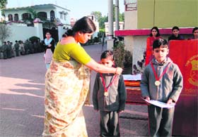 Principal of Indian Academy Neelam Sharma honours two students who excelled in the All-India General Knowledge Intelligence Contest in Dehradun on Tuesday