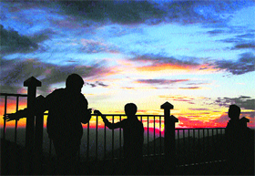 Children enjoy a cloudy sunset in Shimla.