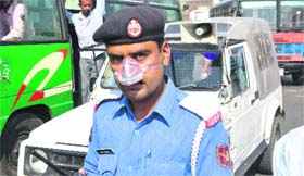 A traffic policeman with his nose covered to guard against noxious gases in Jammu on Tuesday