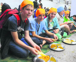 Students from Poland partake of langar on the occasion of Gurpurb at Sector 8 Gurdwara in Chandigarh on Wednesday. 