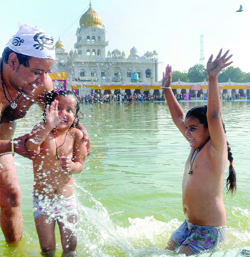 Devotees take a dip in the holy sarovar at Gurdwara Bangla Sahib on the auspicious occasion of the birthday of Sri Guru Nanak Dev in New Delhi on Wednesday.