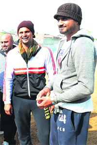 Indian cricketers Suresh Raina and Harbhajan Singh share a lighter moment at the Bhajjis academy in Jalandhar on Wednesday