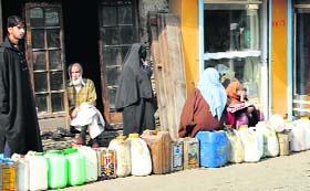 With the recent cap on distribution of LPG cylinders, people wait for their turn to get kerosene in Srinagar on Wednesday