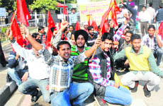 Daily wager safai karamcharis of Guru Nanak Dev University stage a protest outside the main gate of the university in Amritsar on Thursday. 