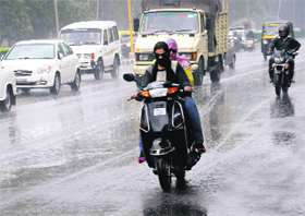 Two-wheeler riders caught unawares by light showers in Chandigarh on Thursday.