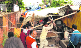 MC workers remove a tent pitched outside former Punjab DGP Shashi Kants house in Sector 18, Chandigarh, on Thursday.
