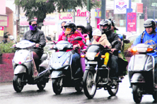 People scurry for cover after a sudden spell of rain in Dehradun on Thursday.