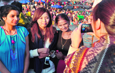 Foreign tourists get themselves clicked with pilgrims in Haridwar. 