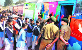 Schoolchildren enter a compartment of Red Ribbon Express at the Raiwala railway station on the outskirts of Haridwar on Thursday. 
