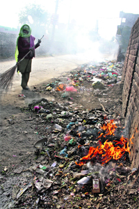 Throwing rules to the wind, municipal sweepers burn solid waste, causing pollution, instead of disposing it off at Prem Nagar in Rohtak on Thursday.
