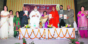 Joonapeethadheeshwar Acharya Mahamandaleshwar Swami Avdheshanand Giri (fourth from right) and Mahamandaleshwar Gita Manishi Swami Gyananand Ji Maharaj (fifth from left) release the poetry book Maan Thandi Chhan, written by Sumedha Kataria (sixth from left), Additional Deputy Commissioner, Kurukshetra, at a function at RK Sadan, Kurukshetra University. 