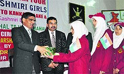 Children receive gifts from a BSF officer after returning from Bharat Darshan tours, in Srinagar on Thursday