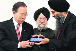 Suneet Singh Tuli (R), CEO of Datawind, presents UN Secretary General Ban Ki-moon (L) with an Aakash2 tablet computer at UN headquarters on Wednesday. India's UN Ambassador Hardeep Singh Puri is also seen.
