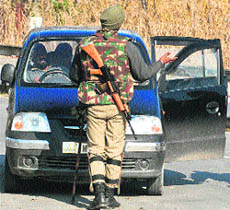 A CRPF personnel stops a car for checking in Srinagar on Friday. 