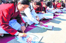 Students of DAV Centenary School, Jagjeetpur, participate in a poster-making competition on World AIDS Day in Haridwar on Saturday.