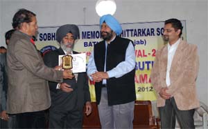 Mayor Baljit Singh Beerbehman gives away an award to an artist on the concluding day of the art fest in Bathinda on Sunday.