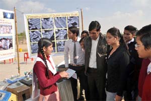 A participant (left) explains to the visitors the construction and working of a solar water bulb. 