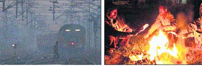 A man crosses railway tracks on a foggy morning in Jalandhar; and (right) with mercury dipping at night, labourers flock around a fire to keep themselves warm in Jalandhar on Sunday. 