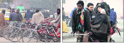Rickshaw-pullers wrap themselves in blankets; and (right) a woman wraps her child in a shawl to keep him cozy as the mercury dips in Jalandhar on Sunday.