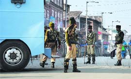 CRPF personnel stand guard during curfew in an area in Srinagar on Monday.