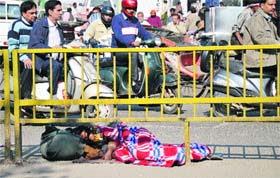 Unaware of the lurking danger, a woman, along with her infant, sleeps under a railing amid heavy traffic near the Damoria bridge in Ludhiana