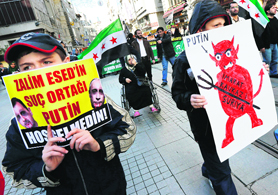 Demonstrators carry signs at a rally against the visit of Russia's President Vladimir Putin in central Istanbul on Monday.