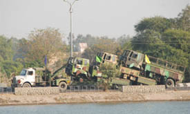 Three Army trucks, tied together, are being ferried by the road adjacent to the thermal lake in Bathinda on Tuesday.