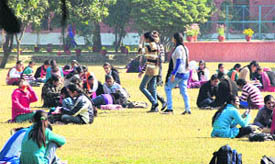 As a bright sun appeared after two days, students of a college enjoy in the garden of the college campus in Jalandhar on Tuesday.