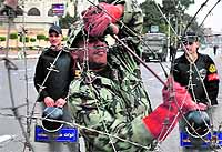 Security personnel lay out barbed wire along a street leading to the presidential palace in Cairo on Tuesday