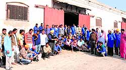 Without work, porters sit outside the rail cargo station near Amritsar railway station