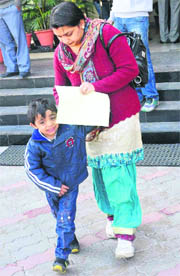A woman leaves with her child after buying the form at Bhavan Vidyalaya Junior School in Sector 33, Chandigarh, on Wednesday