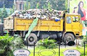 Blatant violation: A garbage truck plies without any cover atop it in defiance of the Punjab and Haryana High Court orders in Jalandhar on Wednesday