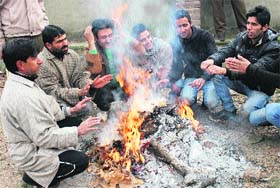 People gather around fire to warm themselves in Srinagar on Wednesday