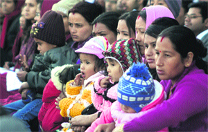 Mothers with their kids watch the Commandants Parade at Indian Military Academy in Dehradun on Thursday.