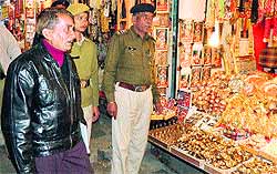 Police and municipal officials direct shopkeepers near the temple gate to clear encroachments on Thursday
