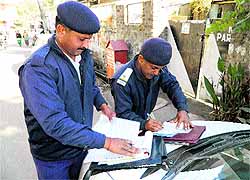 Police officials issue challans to drivers of wrongly parked vehicles in Kangra on Thursday