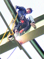 Workers weld a canopy at the stadium without safety gear. 