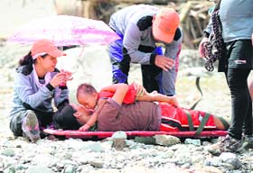 Survivors of Typhoon Bopha being transported across a surging river in New Bataan on Thursday