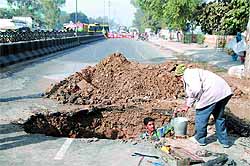 Workers carry out repair work at the place where the water pipe burst on Friday morning