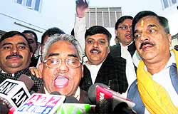 BJP legislators raise slogans in support of their demands while coming out of the state Assembly in Dehradun on Friday