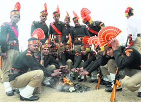 New recruits of the paramilitary Border Security Force (BSF) sit next to a fire to warm themselves.