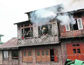 Firefighters and others douse the flames after a fire broke out at Bulbul-Lanker area of downtown Srinagar on Friday. At least three houses were gutted.