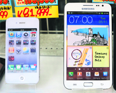 Apple's iPhone (L) and Samsungs Galaxy Note are displayed at a shop in Tokyo. The rivalry of the two tech giants defines a global mobile device industry with a growing list of struggling players. Together, the two mobile juggernauts account for more than 1 in 2 smartphones sold globally.
