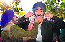 A security guard checks ears of a candidate